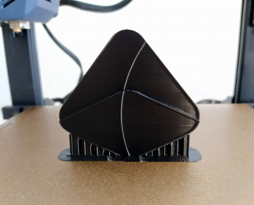 Fertiger Prototype der Bildmarke steht mit seinen Stützen auf dem Bett des 3D-Druckers