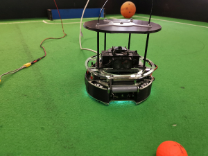 Das Bild zeigt einen Roboter, der für den größten Technik-Schülerwettbewerb RoboCupJunior entwikelt wurde und dort im Bereich "Soccer" antritt. Entwickelt wurde der Roboter von Schüler:innen des Lessing Gymnasiums in Neu-Ulm.