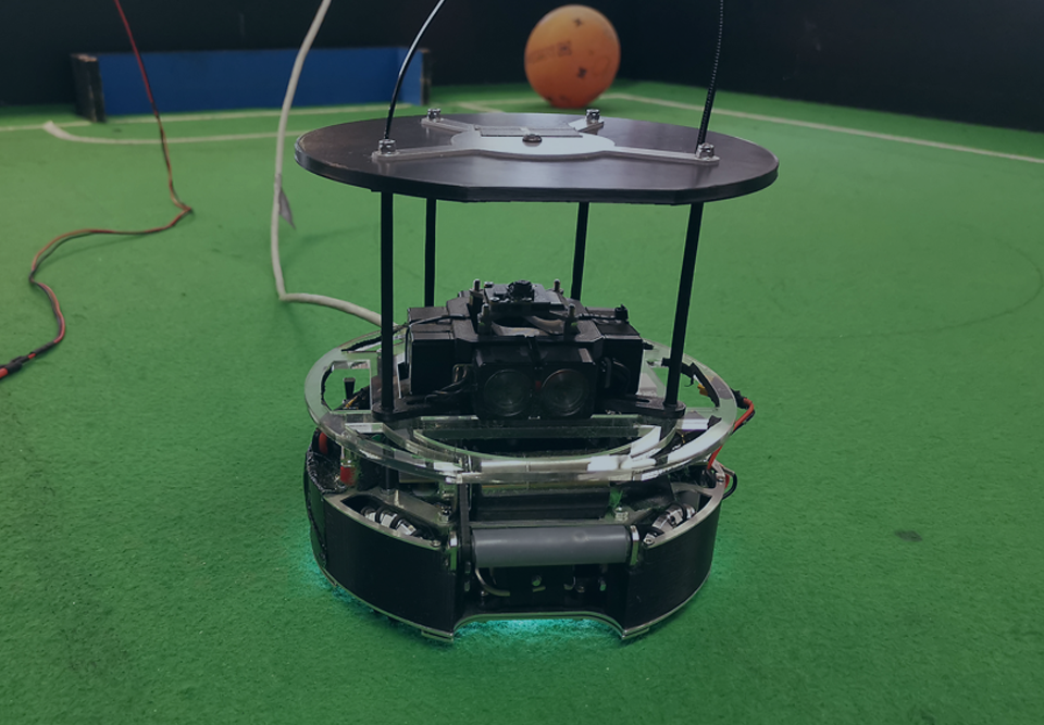 Das Titelbild des Beitrages zeigt einen Roboter, der für den größten Technik-Schülerwettbewerb RoboCupJunior entwikelt wurde und dort im Bereich "Soccer" antritt. Entwickelt wurde der Roboter von Schüler:innen des Lessing Gymnasiums in Neu-Ulm.