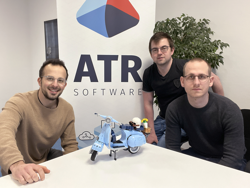 Das Bild zeigt drei Kollegen von ATR Software mit dem zusammengebauten LEGO Modell einer Verspa