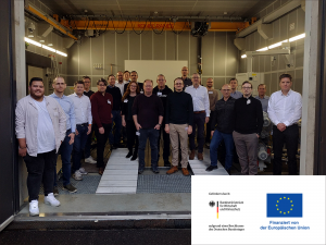 Gruppenbild des Projektkonsortiums vor dem Fahrzeugprüfstand der Hochschule Aalen.