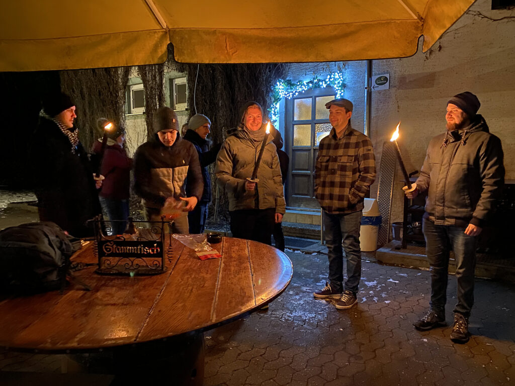 Anzünden der Fackeln vor dem Wirtshaus Silberwald in Neu-Ulm für den Heimweg durch den Wald an der Iller entlang.