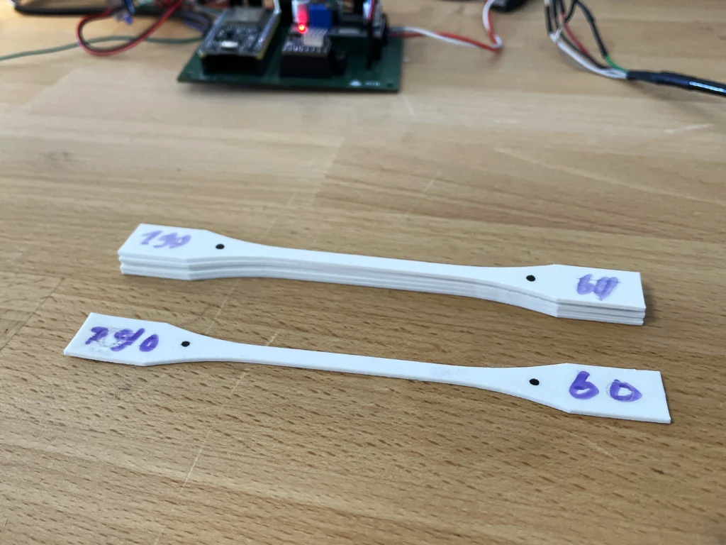 Das Bild zeigt eine Nahaufnahme der Zugstäbe auf der Holzplatte der Werkbank.