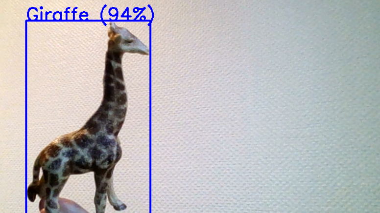 Das Titelbild des Beitrages zeigt eine Spielzeugfigur in Form einer Giraffe. Um sie herum befindet sich ein Rahmen mit der Information, dass sie von YOLO zu 94% als Giraffe erkannt wird.